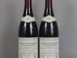 two bottles of wine sitting on top of a table next to each other