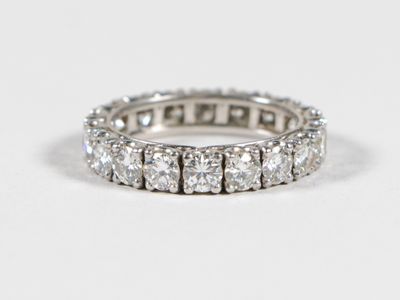 a close up of a diamond ring on a white surface