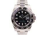 rolex watch with black dial and green hands on a stainless steel bracelet
