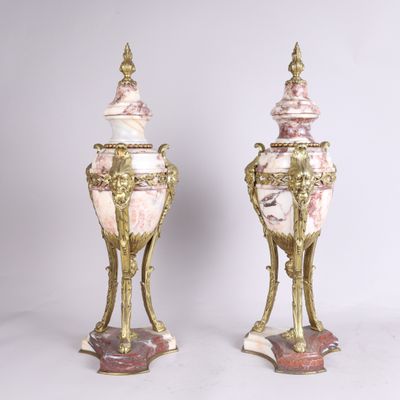 une paire de vases anciens roses et dorés posés sur des socles, sur fond blanc
