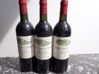 three bottles of red wine sitting on a table