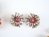pair of silver and red earrings with pearls on a white surface