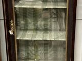 une vitrine aux portes vitrées, placée dans un coin de la pièce