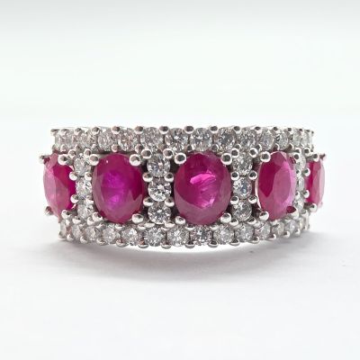 a close up of a pink and white diamond ring on a white surface