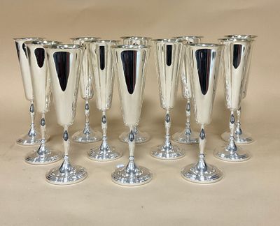 six verres à vin en argent sont alignés sur une table