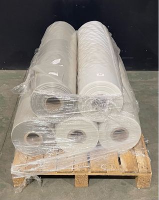 several rolls of plastic are stacked on a pallet in a warehouse