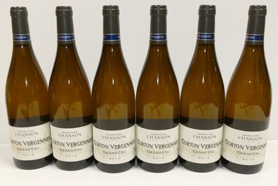 six bouteilles de vin sont alignées sur une surface blanche