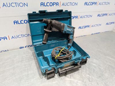 an open tool box with a drill and a cord in it