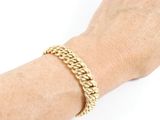 an image of a woman ' s hand wearing a gold chain bracelet