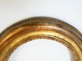 a picture of a gold framed mirror on a white wall