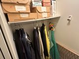 a closet with a lot of clothes and boxes on the shelves