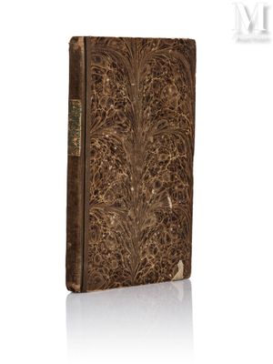 un vieux livre dont la couverture est ornée d'un motif floral