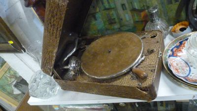 un tourne-disque posé sur une étagère, à côté d'une assiette