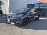 une Nissan Murano grise garée devant un immeuble