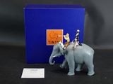 une figurine représentant deux personnes chevauchant un éléphant