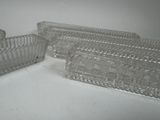 three pieces of glass on a table with a white background