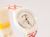 Quelqu'un porte une montre avec un motif rouge et blanc.