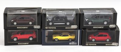 six modèles différents de voitures dans des boîtes, posées sur une surface blanche