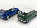 two miniature cars that are next to each other on a white surface