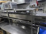 plan de travail en acier inoxydable dans une cuisine professionnelle équipée de fours à micro-ondes et d'autres appareils électroménagers