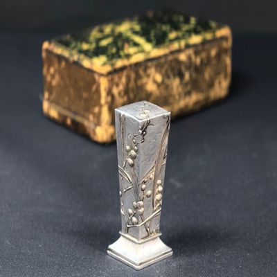 un gros plan d'un objet métallique posé sur une table, à côté d'une boîte