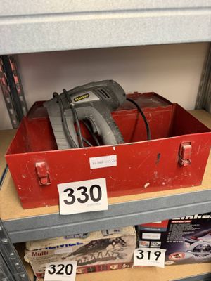 a red box with a tool on top of it on a shelf