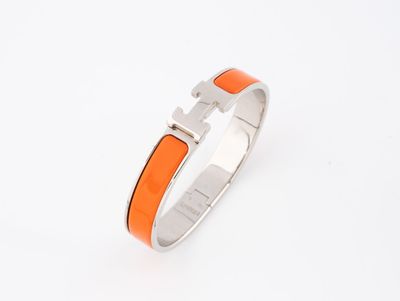 un bracelet orange et argent orné d'une croix
