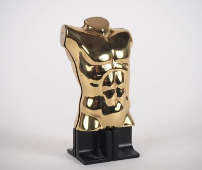 a gold statue of a torso on a black stand