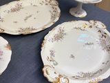 many plates and bowls on a table with a blue table cloth