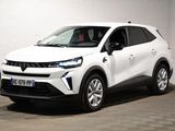 le SUV blanc est garé dans une pièce au sol en damier