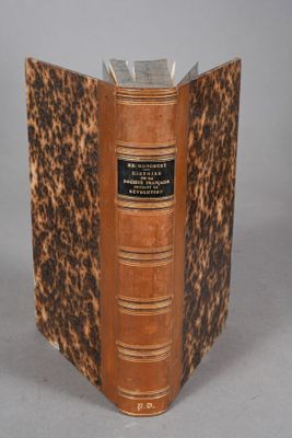 an old book with a brown cover sitting on top of a table