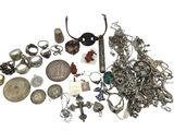 a pile of silver jewelry on a white surface