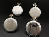three different types of pocket watches are displayed on a black surface