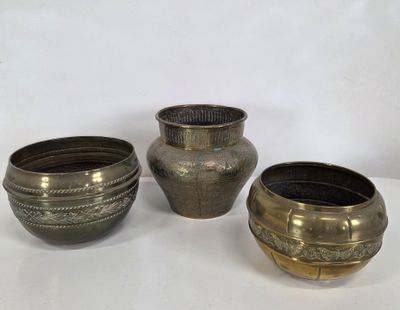 three silver vases sitting next to each other on a white surface