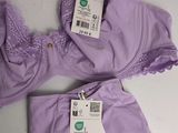 two purple bras with tags on them sitting on a white surface