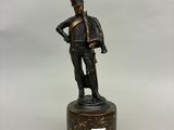 une statue en bronze représentant un soldat armé d'une épée, posée sur un socle
