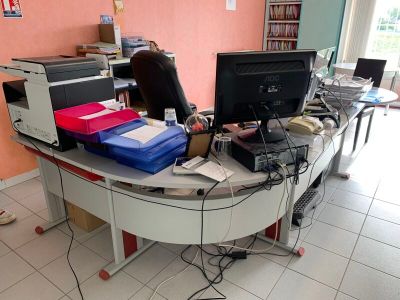 un bureau sur lequel se trouvent un ordinateur, une imprimante et d'autres objets
