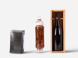 a bottle of wine next to a box and a bottle of wine