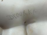 a white statue of a woman with writing on her chest