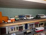 de nombreuses petites voitures et camions sur une étagère dans un magasin de jouets