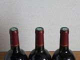 three bottles of wine sitting on a table next to each other