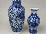 two blue and white vases sitting next to each other on a table