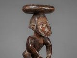 a wooden sculpture of a man with a hat on his head