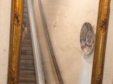 un miroir sur le mur au-dessus d'un lavabo dans une salle de bains