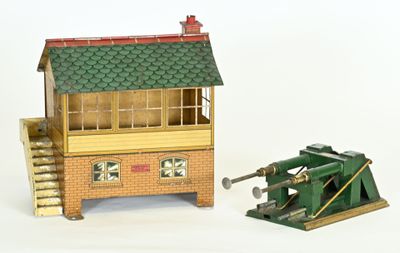 une petite maquette représentant un bâtiment et un canon