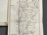 an open book with a map on it sitting on top of a table
