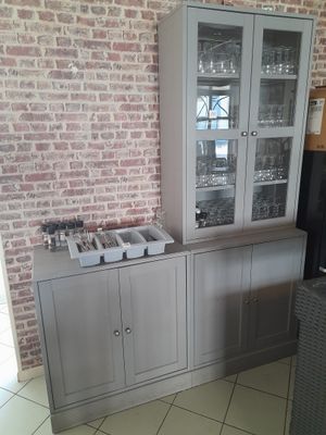 une armoire avec une porte vitrée dans un coin de la pièce