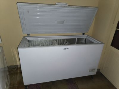 a white chest freezer sitting in the corner of a room