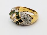 a close up of a gold ring with green and white stones