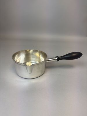 une casserole argentée avec une poignée noire sur un fond blanc